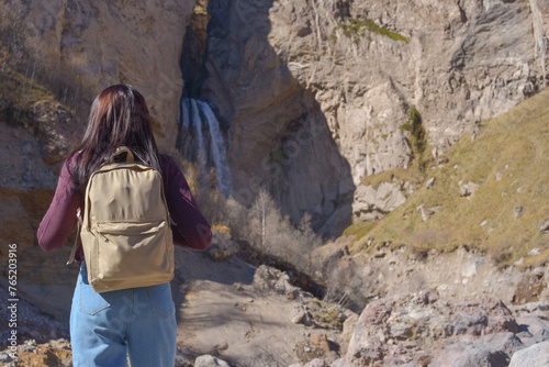 Travel. The girl travels through the mountains and waterfalls of the wild. Unity, mental health, eco-travel. Hiking, traveling, good times, digital detox