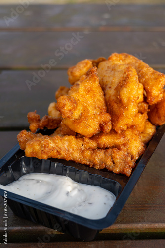 Outdoor eating of diep-fried cod fish pieces served with remoulade sauce, Dutch street food photo