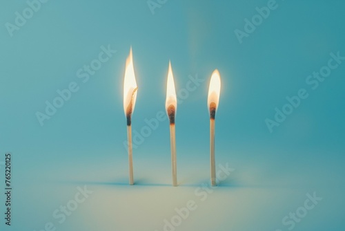 Three lit matches on a blue background