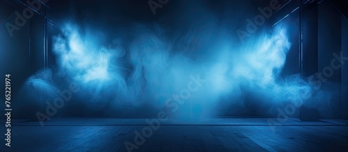 A dimly lit room with electric blue lights and smoke billowing from the ceiling  creating a calm atmosphere reminiscent of a mysterious landscape under a dark sky