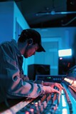 A music producer working in a studio with faders