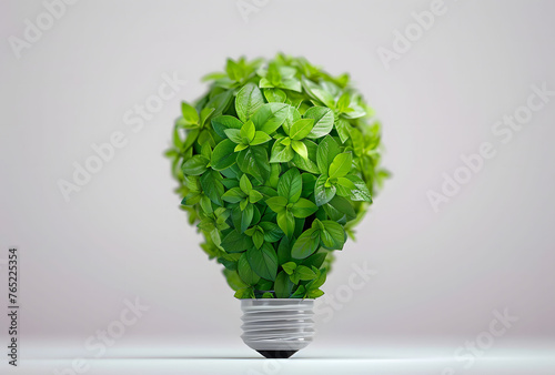 An eco-friendly concept is represented by a light bulb composed of green leaves against a white background. Concept of eco energy and environment protection. Copy space.