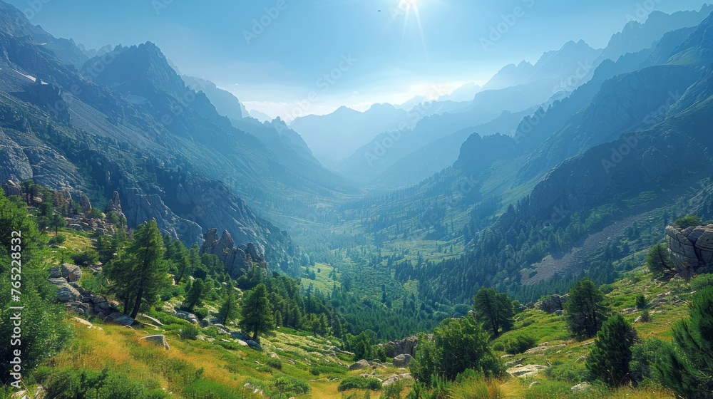 A lush valley nestled among towering mountains and trees under a sunny sky