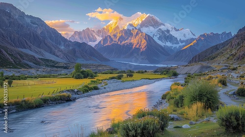 River flows through valley with mountains in the background, under cloudy sky