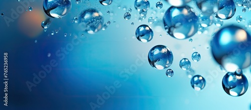 Close-up image of numerous transparent water droplets gathered on a vibrant blue background