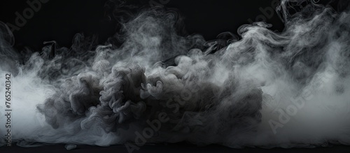 Smoke is seen swirling in the air against a dark black backdrop