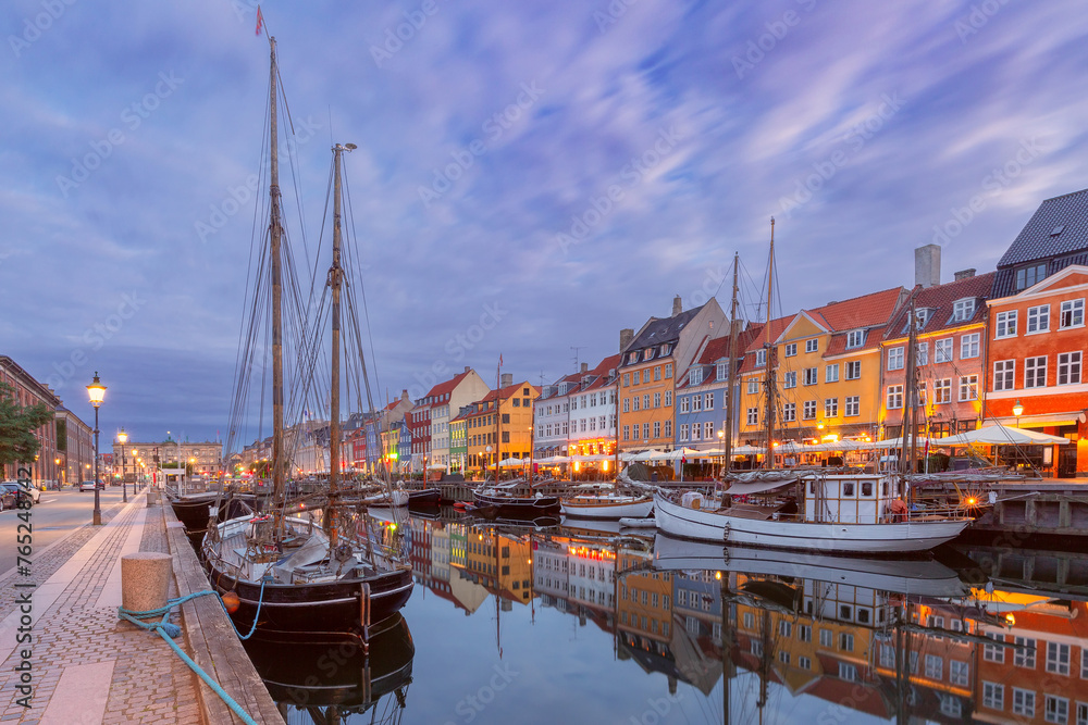 Nyhavn with colorful facades of old houses and ships in Old Town of Copenhagen, capital of Denmark.