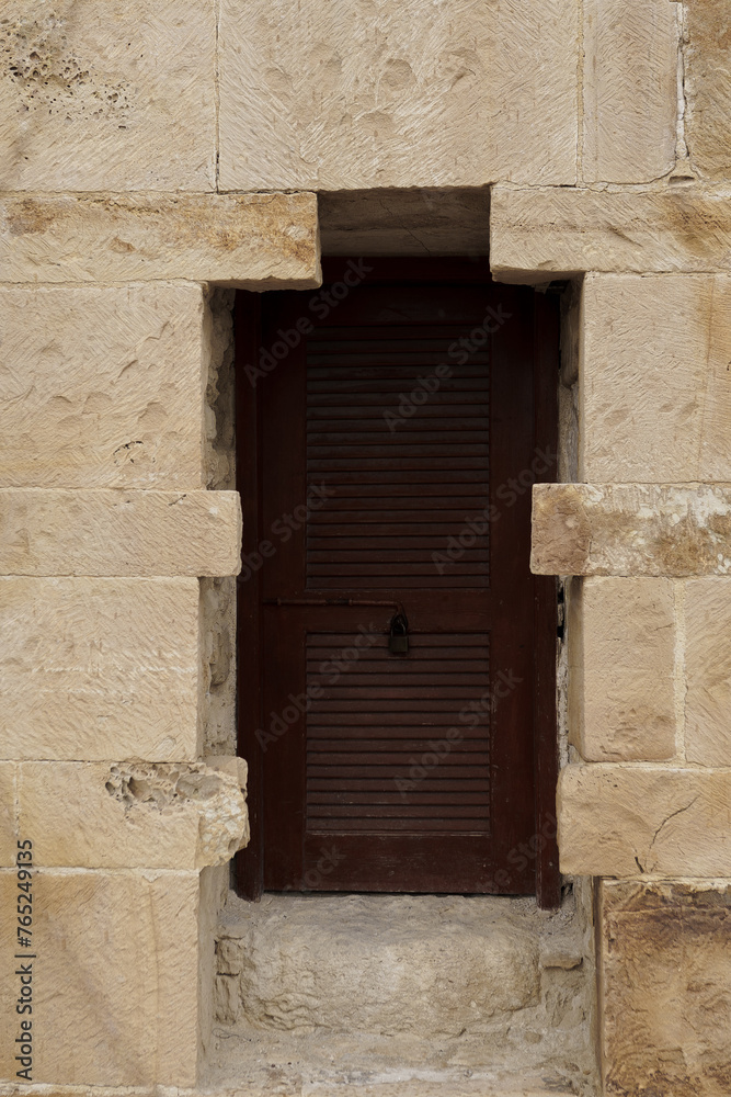 Dark brown door in in white stone wall Lagos