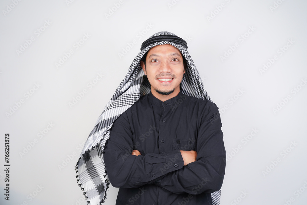 Happy and confident asian muslim man wearing Arab turban sorban standing with crossed arms isolated Happy and confident asian muslim man wearing Arab turban sorban standing with crossed arms isolated