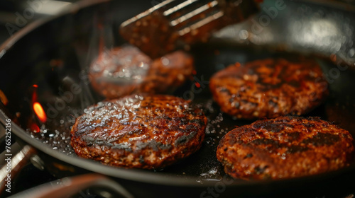 Ground beef patties sizzling in a hot frying pan, cooking to a golden brown perfection.