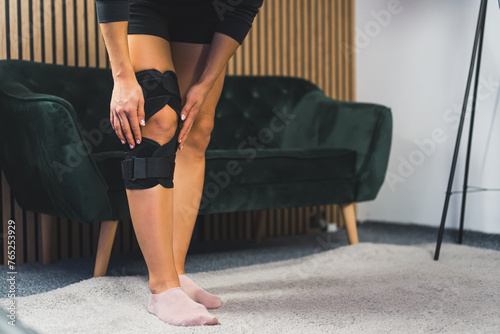 Photo of women leg in knee brace at home, injuries and pain. High quality photo