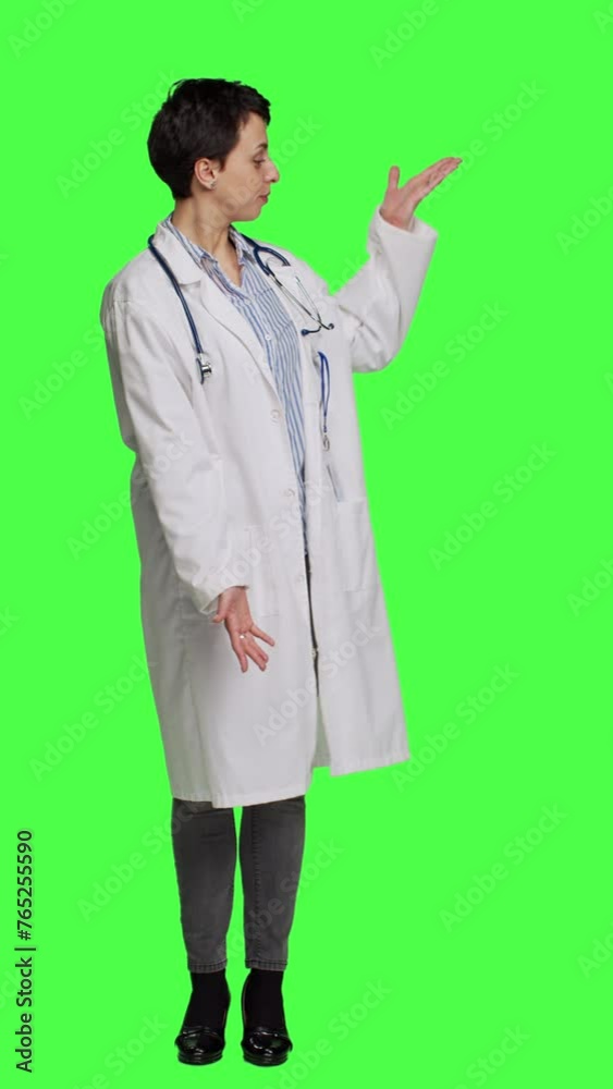 Front view Woman medic does web advertisement against greenscreen backdrop, pointing to left and right sides in studio. Doctor with white coat advertising something for a commercial. Camera A. Front view Woman medic does web advertisement against greenscreen backdrop, pointing to left and right sides in studio. Doctor with white coat advertising something for a commercial. Camera A.