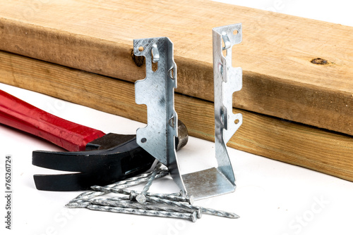 Photos A galvanized steel joist hanger with hammer and nails as be used n residential c