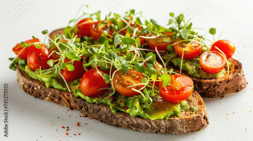 Avocado toast with cherry tomatoes and microgreens on artisan sourdough bread. Minimalistic presentation on a white background