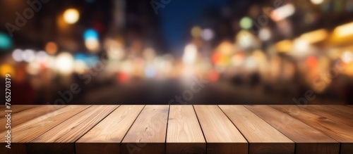 A wooden table top is shown with a backdrop of blurred city lights in the distance