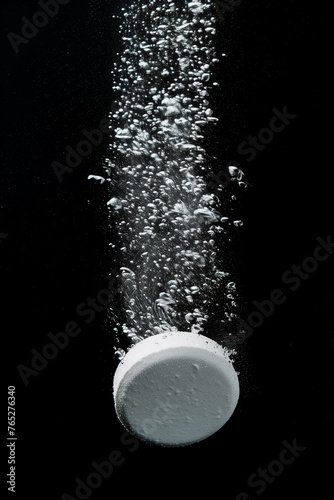 Effervescent tablet pill in fizzy bubbles water, realistic transparent effect. Soluble tablet or effervescent pill sparkling fizz in water for vitamin or aspirin pill falling down dissolving photo