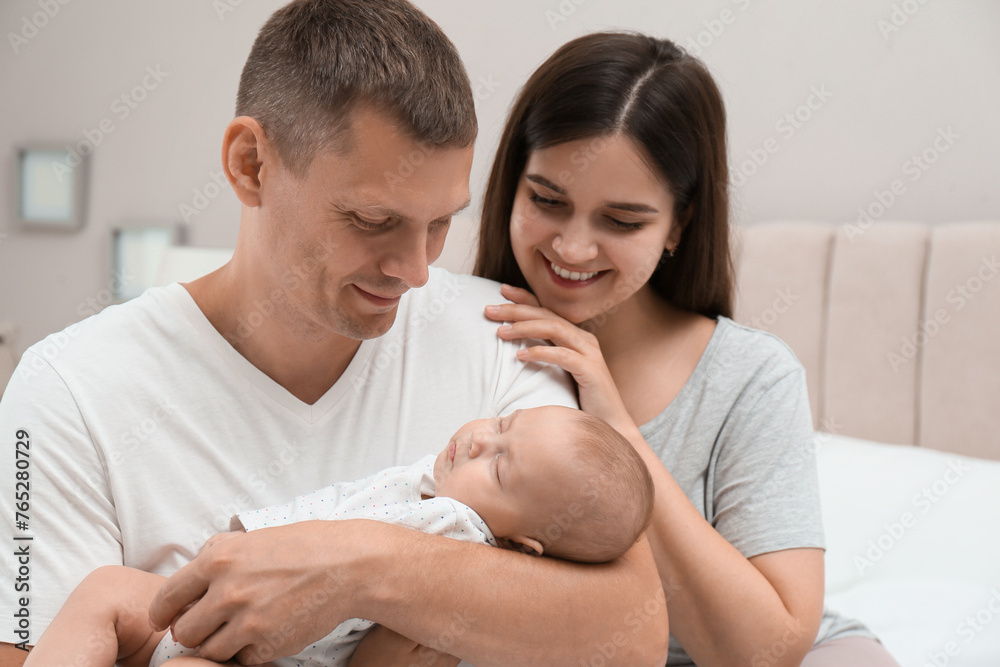 Happy family with their cute sleeping baby at home Happy family with their cute sleeping baby at home