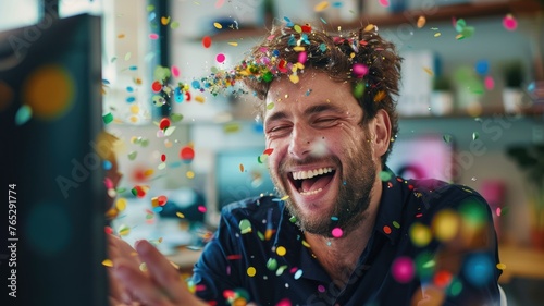 Man laughing amidst shower of confetti - Overjoyed man with confetti explosion, laughing uncontrollably photo