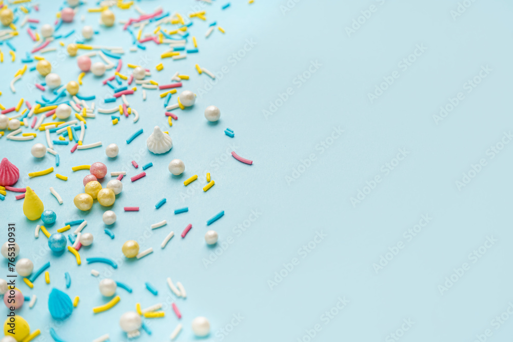 Fototapeta premium Sweet colorful sprinkles scattered on blue background