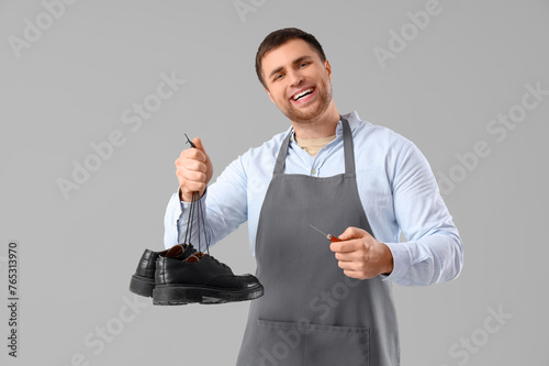Male shoemaker with boots a...
