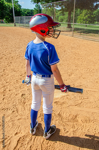 Youth preteen boy baseball player standing at home plate with bat ready to play