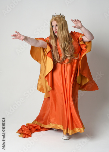 Full length portrait of plus sized woman blonde hair, wearing historical medieval fantasy gown with long flowing sleeves, golden crown of royal queen. Standing pose, isolated studio background.