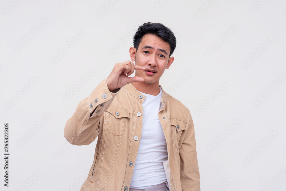Cocky young Asian man mocking someone's small manhood with his hand, isolated on white