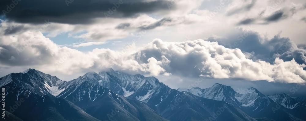 view of mountains covered in snow with cloudy skies in winter