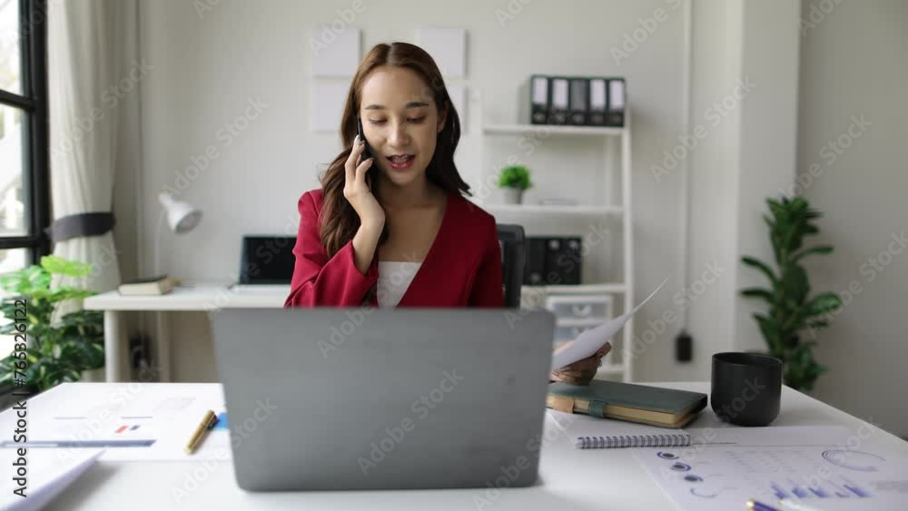 Asian businesswoman in the office talking on the phone with a customer. Asian businesswoman in the office talking on the phone with a customer.