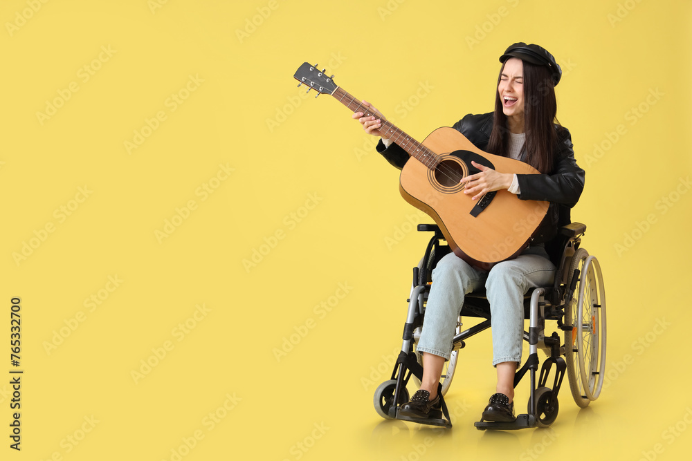 Female artist in wheelchair with guitar singing on yellow background Female artist in wheelchair with guitar singing on yellow background