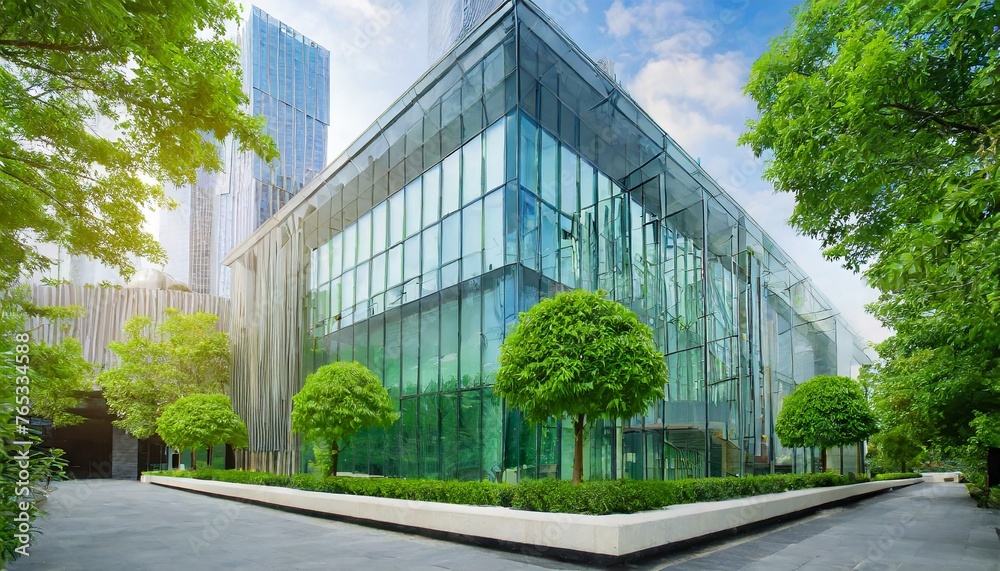 Eco - friendly building in the modern city. Sustainable glass office building with trees for reducing heat and carbon dioxide. Office building with green environment