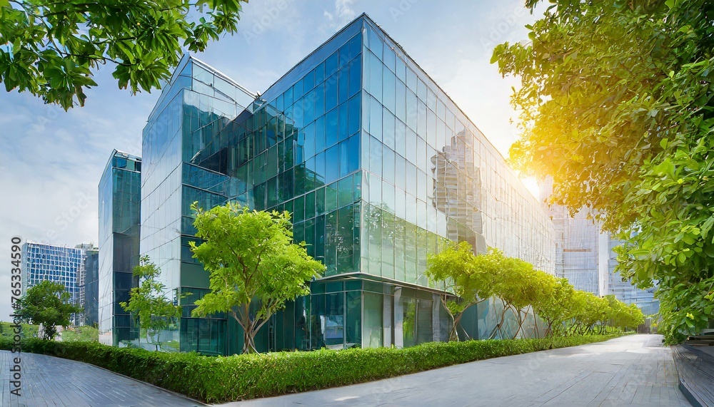 Obraz premium Eco - friendly building in the modern city. Sustainable glass office building with trees for reducing heat and carbon dioxide. Office building with green environment