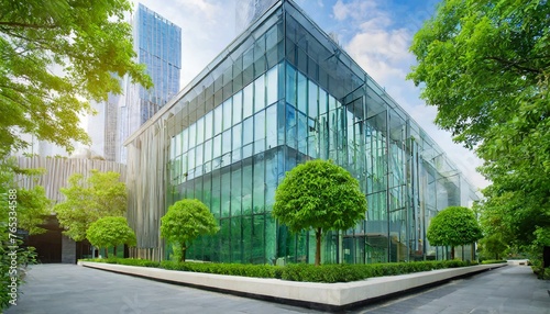 Eco - friendly building in the modern city. Sustainable glass office building with trees for reducing heat and carbon dioxide. Office building with green environment