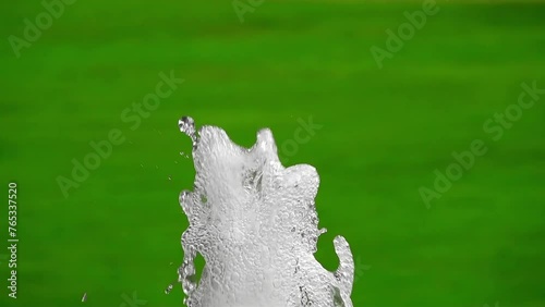 Slow-motion artesian fountain on green background