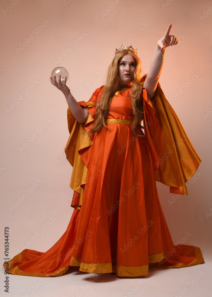 Full length portrait of plus sized woman blonde hair, wearing historical medieval fantasy gown, golden crown of royal queen. Standing pose holding crystal seer orb, isolated studio background. Full length portrait of plus sized woman blonde hair, wearing historical medieval fantasy gown, golden crown of royal queen. Standing pose holding crystal seer orb, isolated studio background.