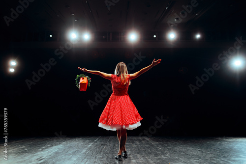 Happy Performer Greeting the Audience Receiving Flowers. Talented actress getting standing ovations for her performance 
 photo