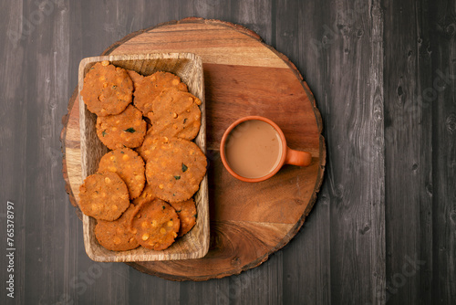 Thattai or Nippattu or Chekkalu is a south Indian deep fried snack made with rice flour and daily common tea time snack.  Thattai is a south Indian fried snack, Spicy and Crispy with karak chai photo