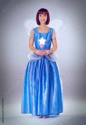 Принти на полотні Woman, fairy godmother and smile in studio portrait with wand, wings and dress for magic by background