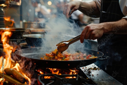 A person is cooking food on a grill with flames, creating a BBQ meal outdoors