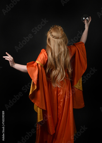close up portrait of plus sized blonde woman, wearing historical medieval fantasy gown, crowned royal queen.  posing holding magic crystal seer orb, isolated dark black studio background.