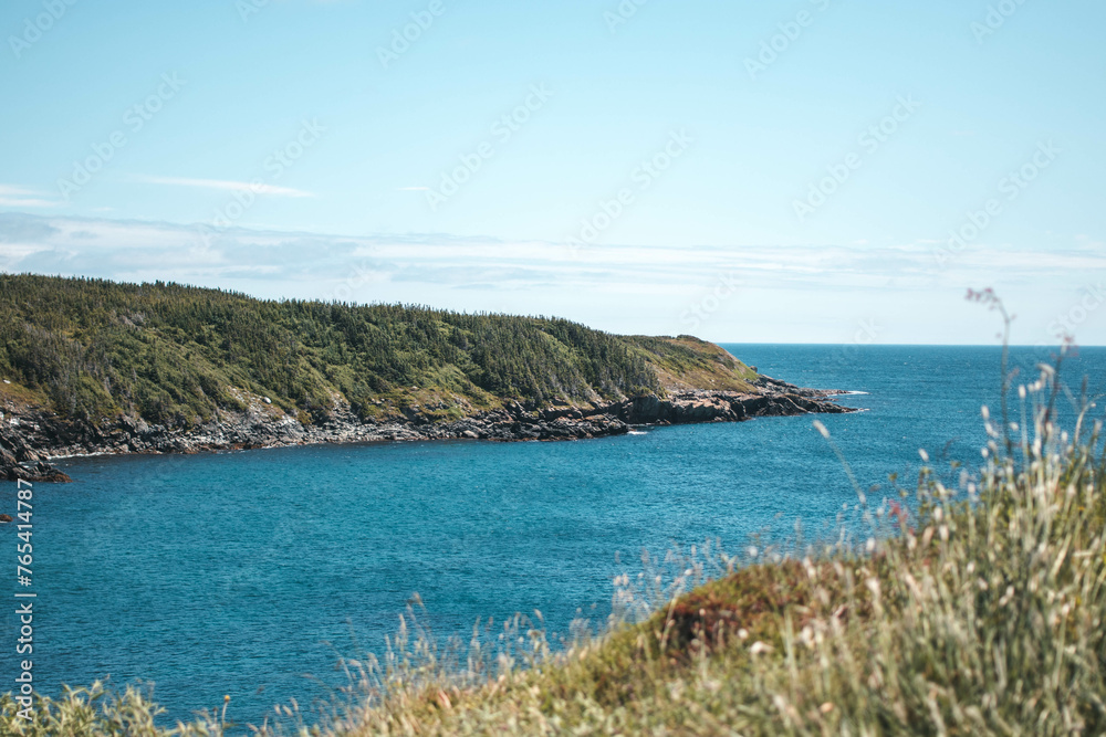 Blue waters surround rock formation on sunny day