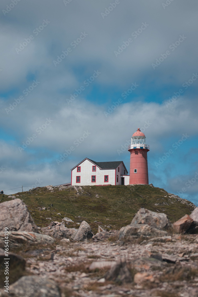 Ferryland lighthouse with rocks and clouds