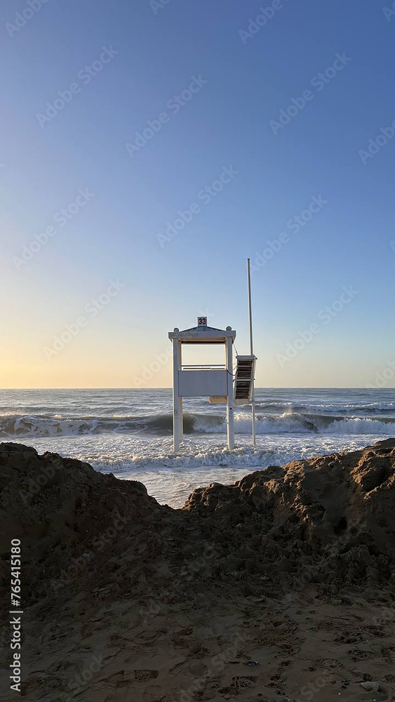 lifeguard tower in the middle of rough seas and reefs at sunrise lifeguard tower in the middle of rough seas and reefs at sunrise