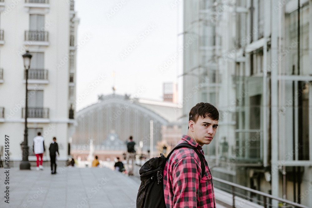 Young Man With Backpack Standing in Front of Building