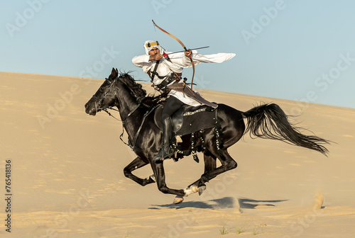 Arabian horseback archer riding his stallion and aiming at targets with his bow and arrow