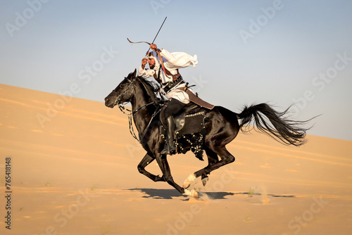 Arabian horseback archer riding his stallion and aiming at targets with his bow and arrow