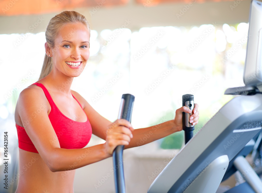 Obraz premium Woman, gym and fitness with machine for wellness and cardio training for elliptical exercise. Athlete, happy and routine with confidence and natural strength for wellbeing or workout portrait