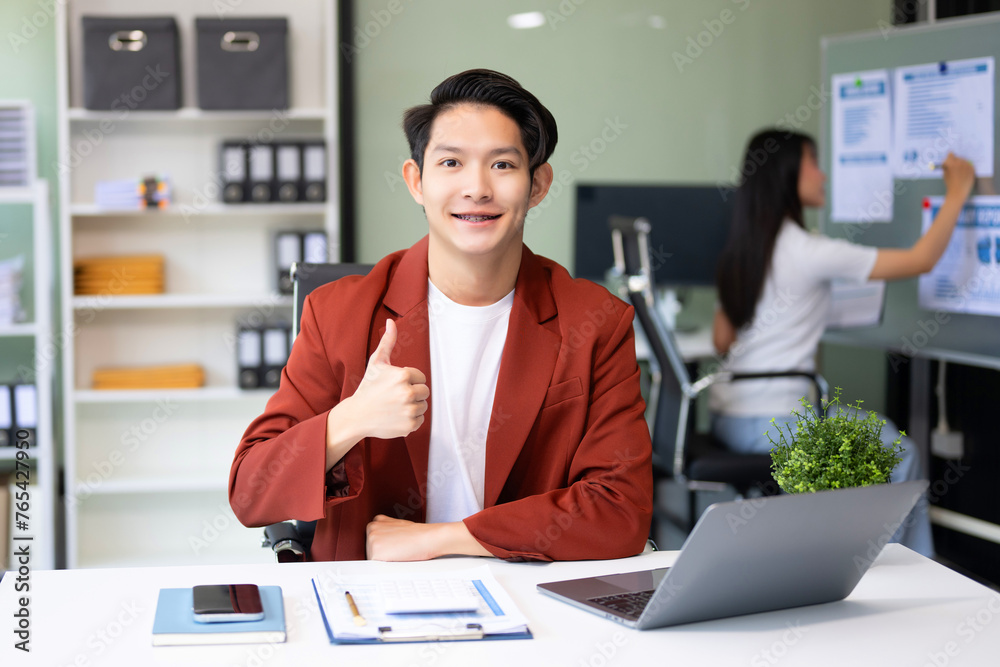 Young attractive Asian male office worker business suits smiling at camera Young attractive Asian male office worker business suits smiling at camera