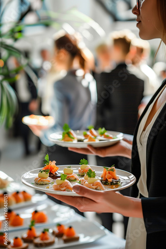 Woman holding plate with snacks and canape on buffet with people in the background