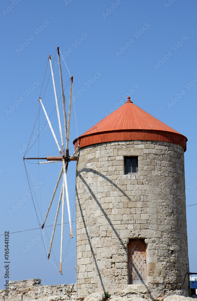 Old Greek Windmill  with Blue Sky Background by The Port in Rhodes, Greece